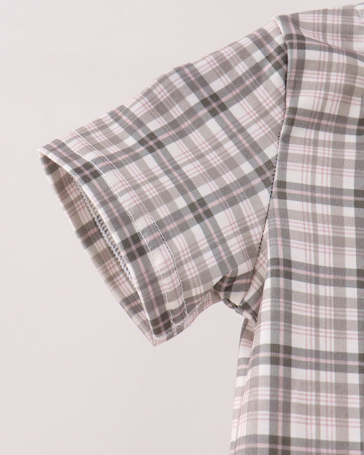 Close-up of a short-sleeve plaid shirt in white, gray, and light pink, showing the sleeve cuff and fabric texture against a light gray background.