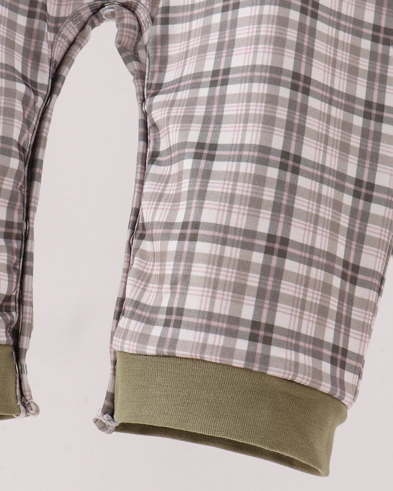 Close-up of a plaid pajama or lounge pant leg with a soft ribbed olive green cuff, shown against a plain light background.