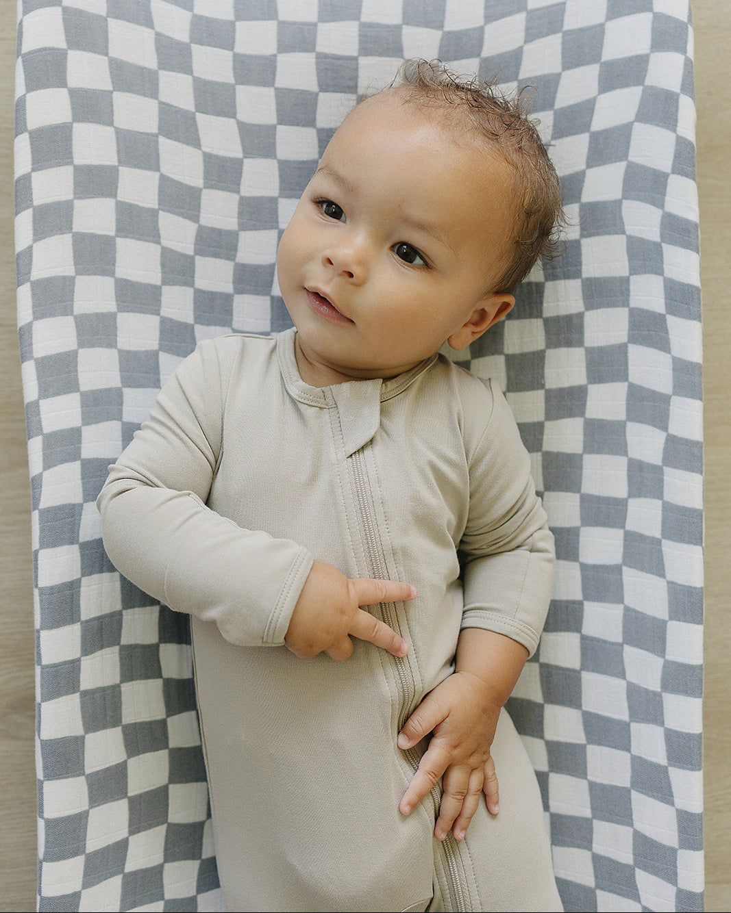 Baby lying on a checkered blanket