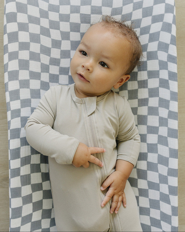 Baby lying on a checkered blanket
