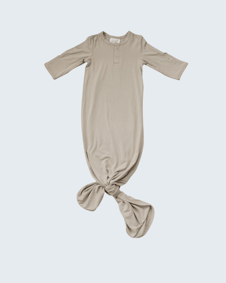 Beige baby gown with a knot on a white background