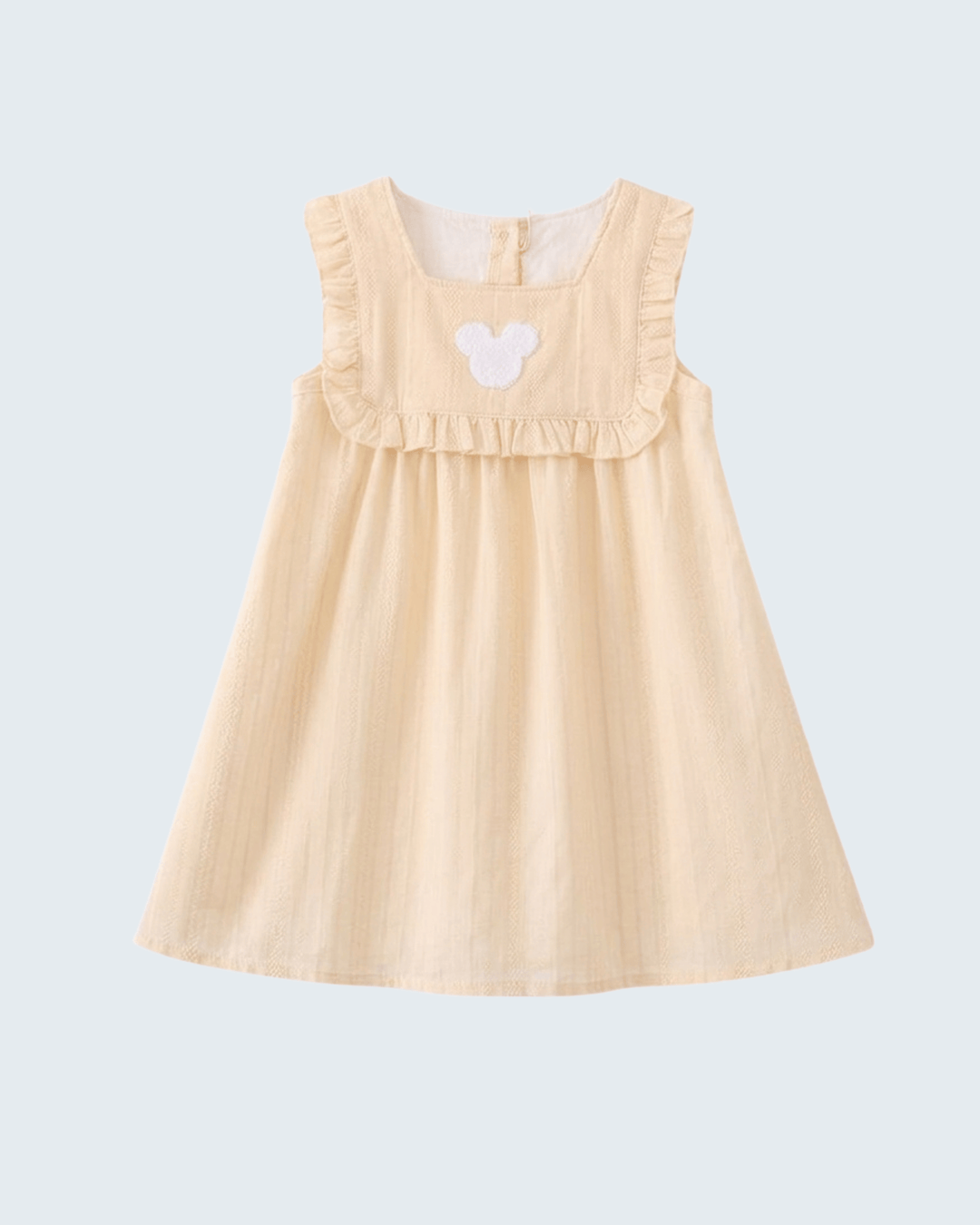 A sleeveless baby dress in a light cream or pale yellow fabric, featuring a ruffled neckline and a small white embroidered butterfly on the chest, shown against a solid light blue background.