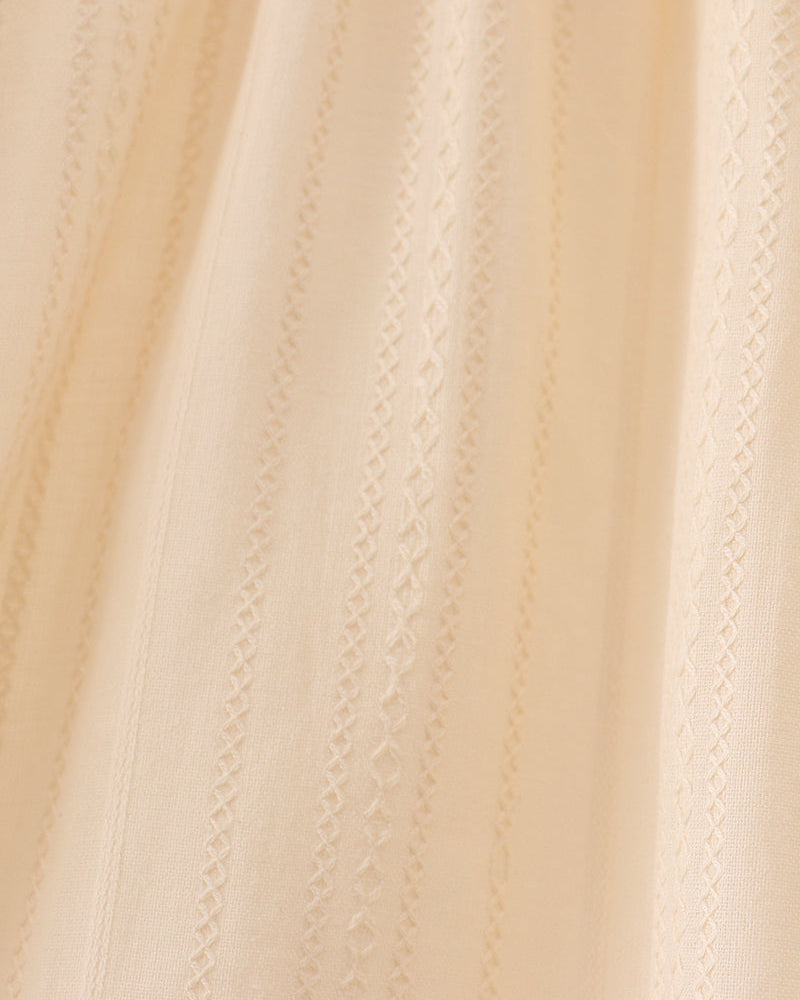 Cream fabric with vertical textured stitching and scalloped panel seams