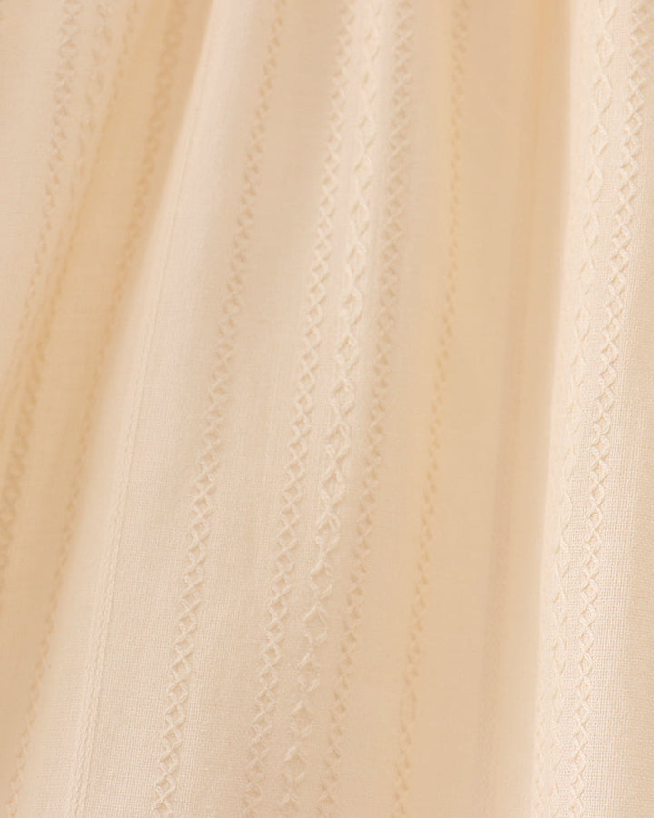 Cream fabric with vertical textured stitching and scalloped panel seams