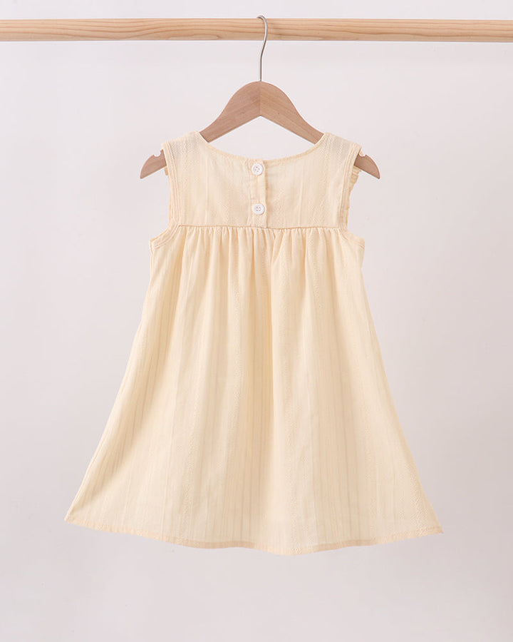 Cream sleeveless dress with button placket and gathered yoke ruffles