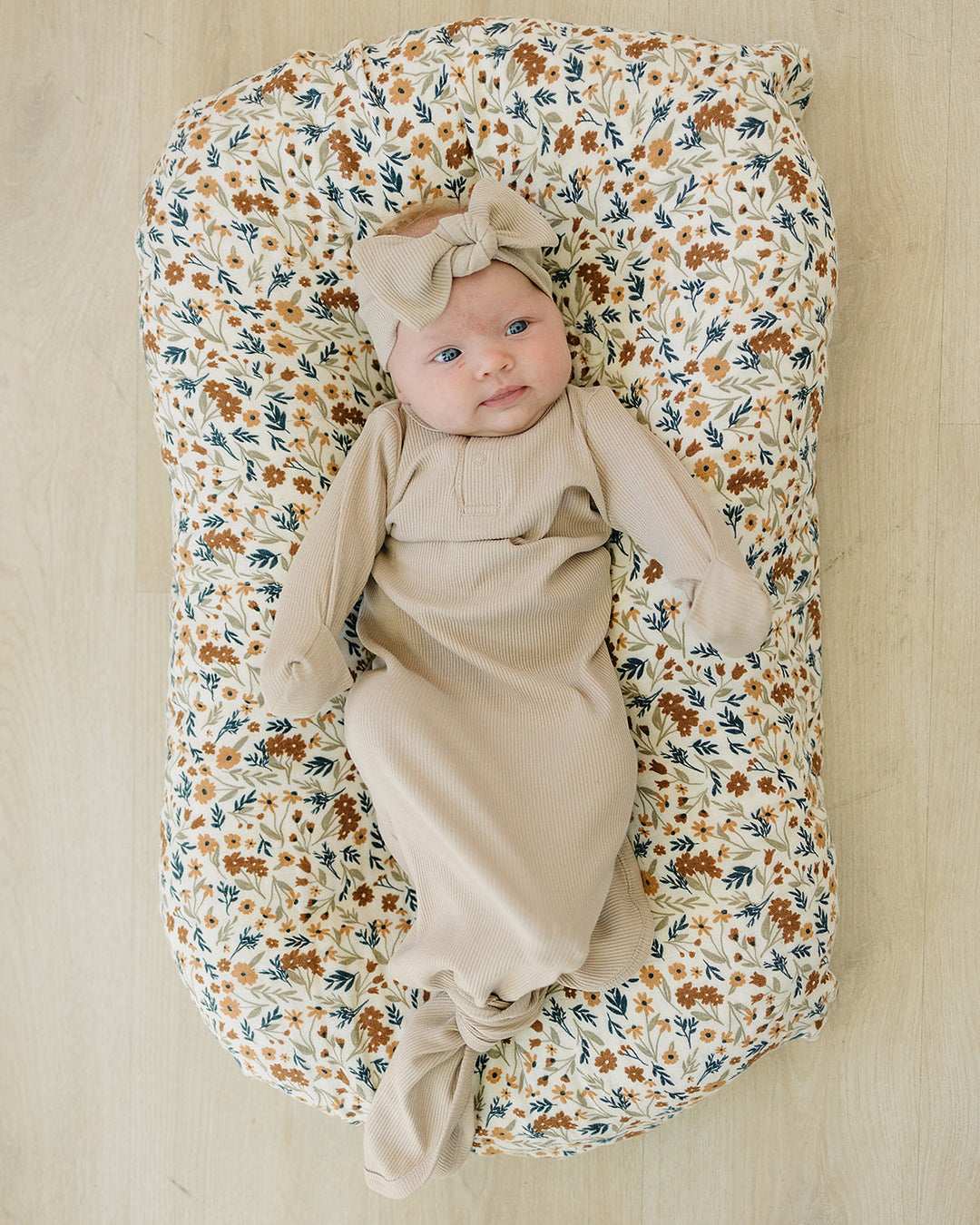 Ivory ribbed baby head wrap with knotted bow, worn by an infant