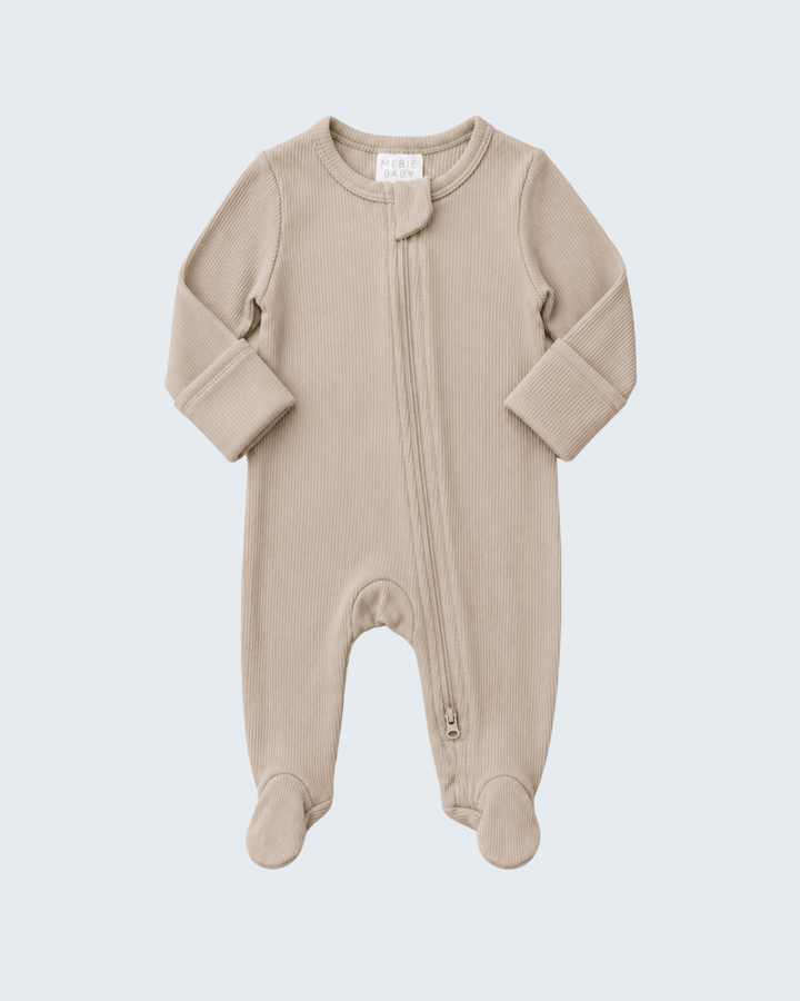 A light beige ribbed knit baby footed sleeper with a front zipper, displayed on a solid light gray background.
