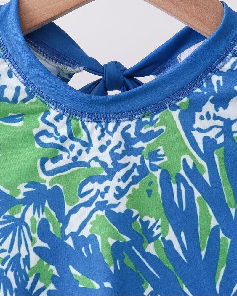 Close-up of a blue and green patterned garment on a wooden hanger.