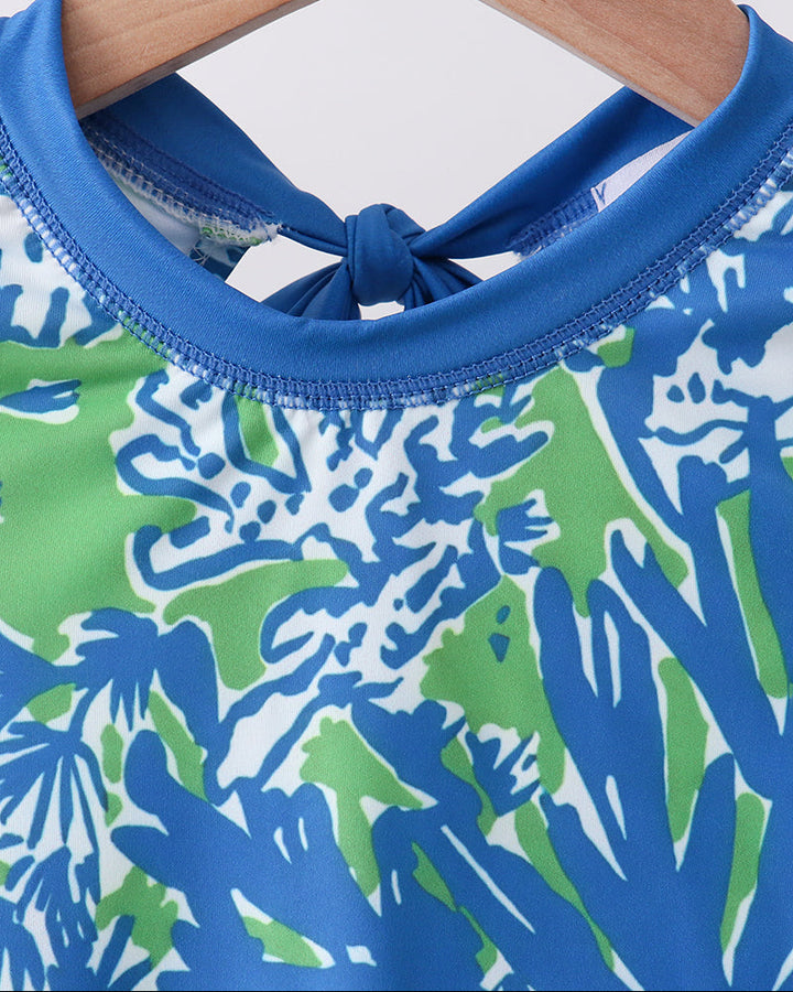 Close-up of a blue and green patterned garment on a wooden hanger.