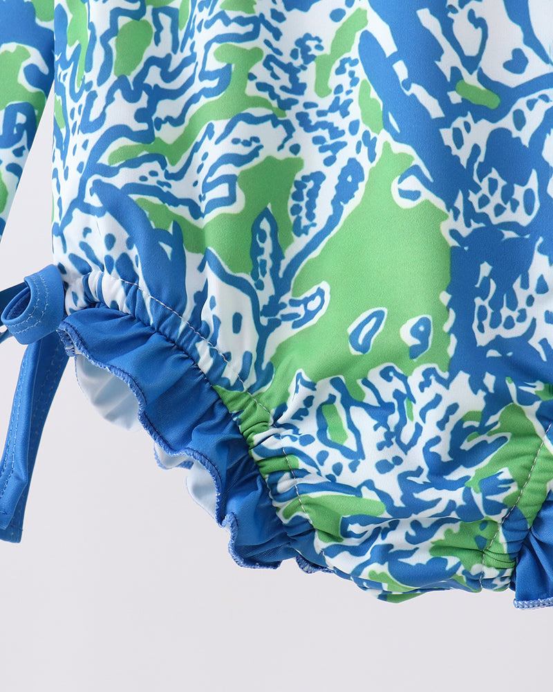 Close-up of a blue and green patterned swimsuit on a white background