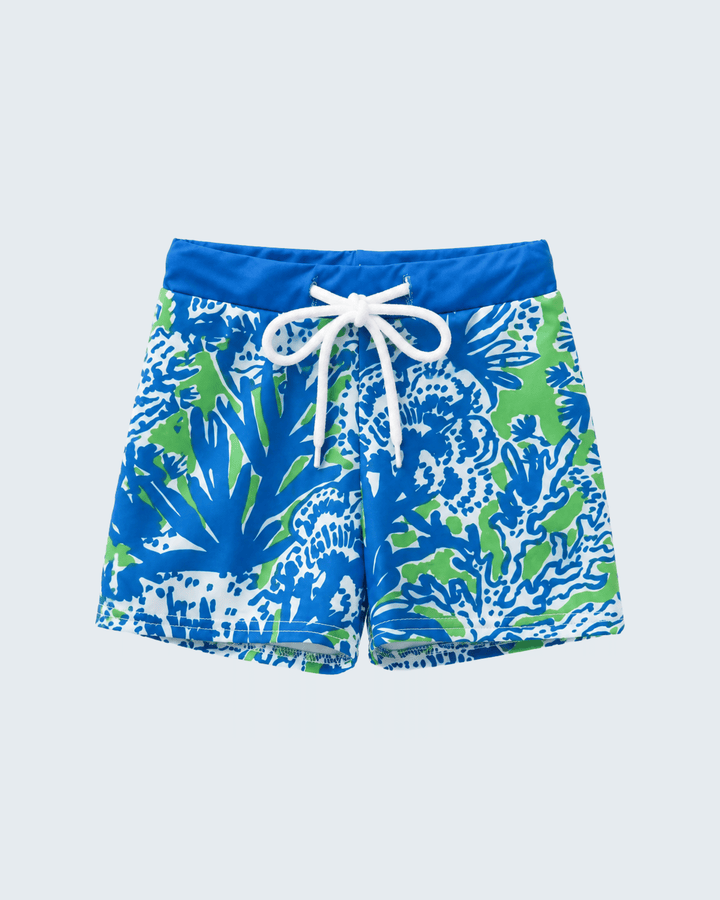 Blue and green patterned swim shorts with a white drawstring on a light gray background