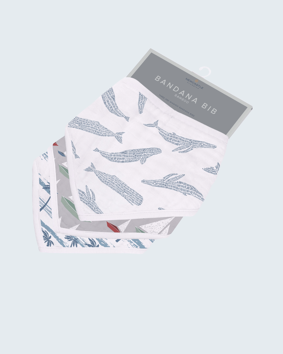 Packaged bandana bib with whale pattern on a light gray background