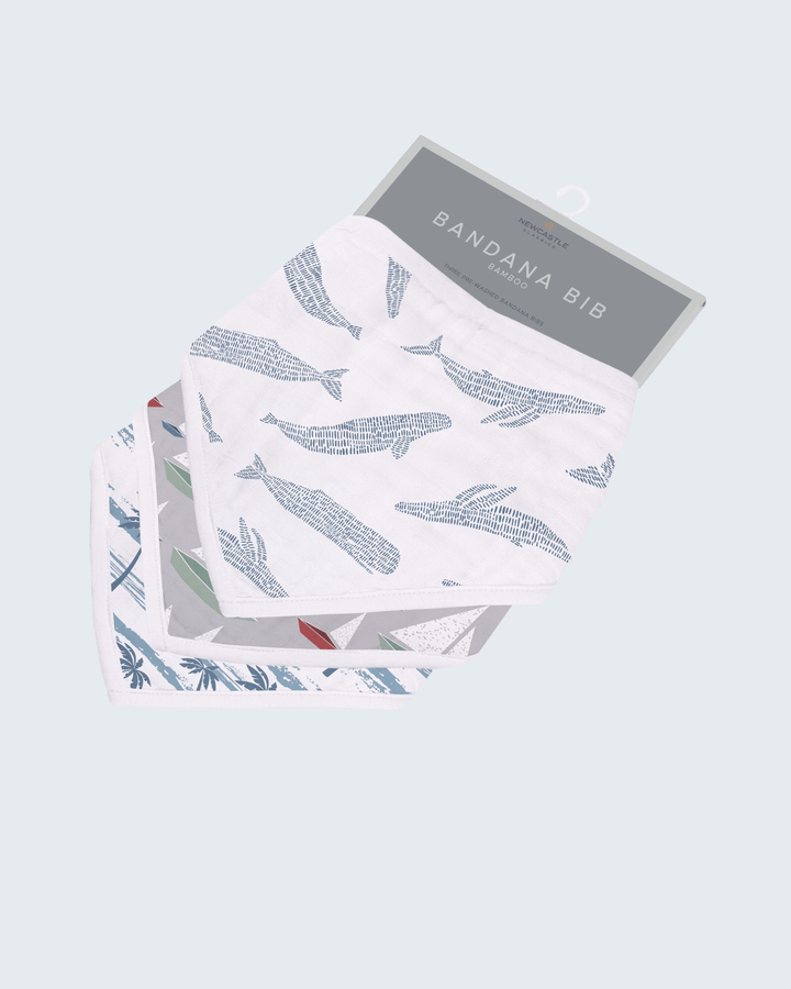 Packaged bandana bib with whale pattern on a light gray background