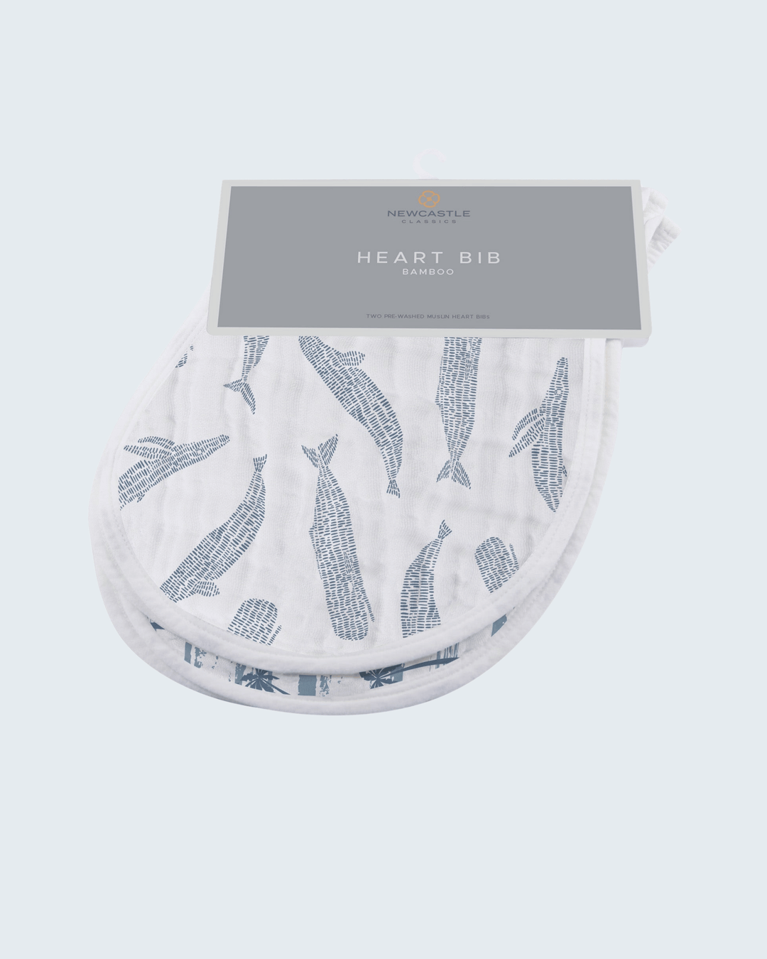 Heart-shaped bib with whale pattern and packaging on a white background
