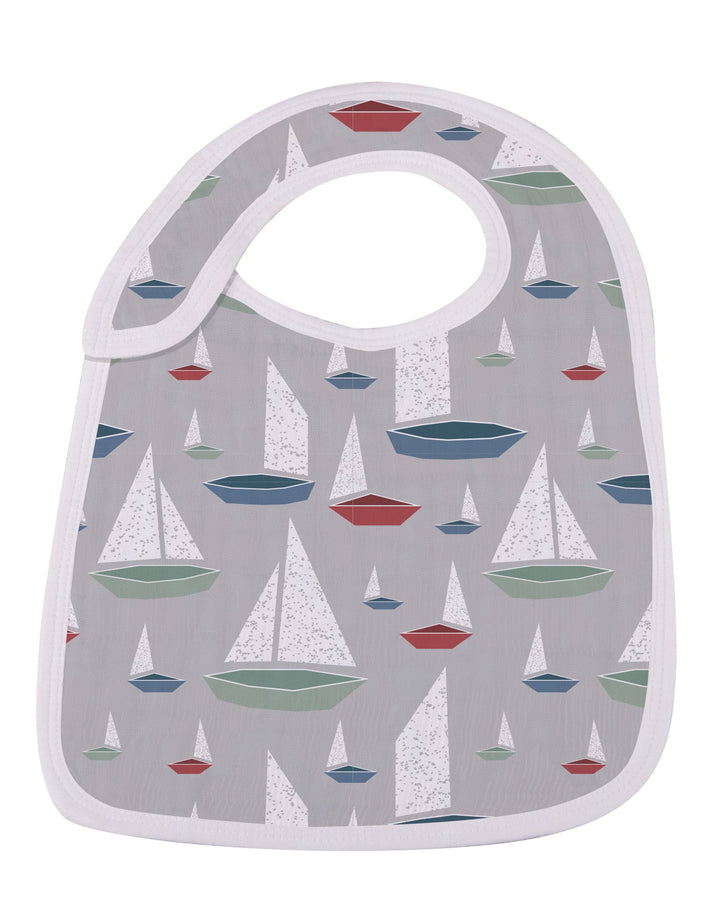 Baby bib with sailboat pattern on a gray background