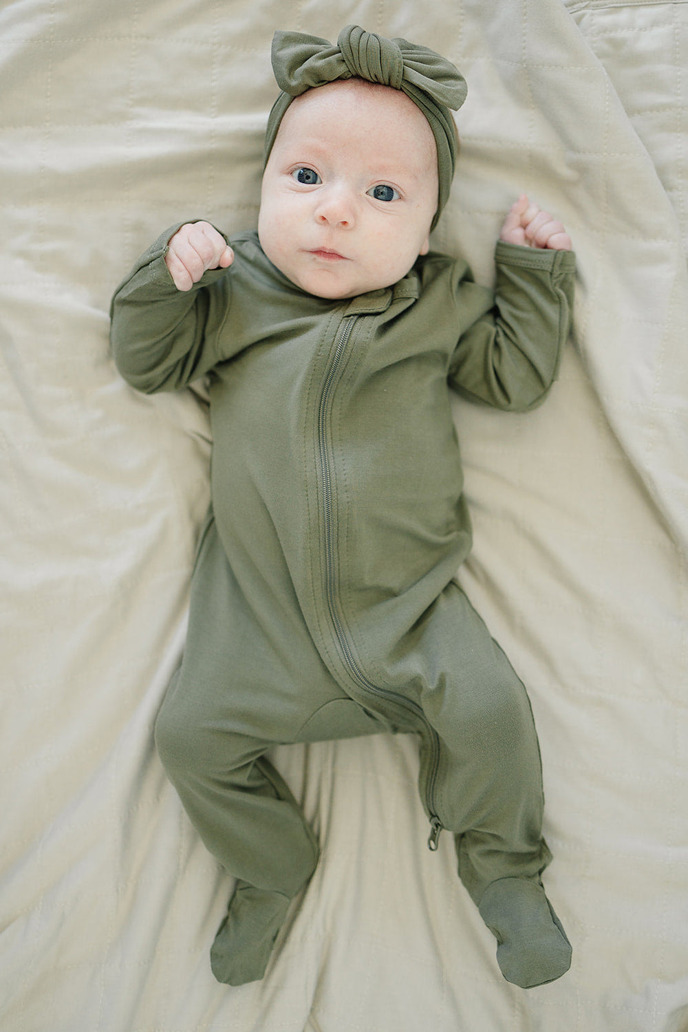 Close-up of an olive green knotted bamboo head wrap bow on a baby.