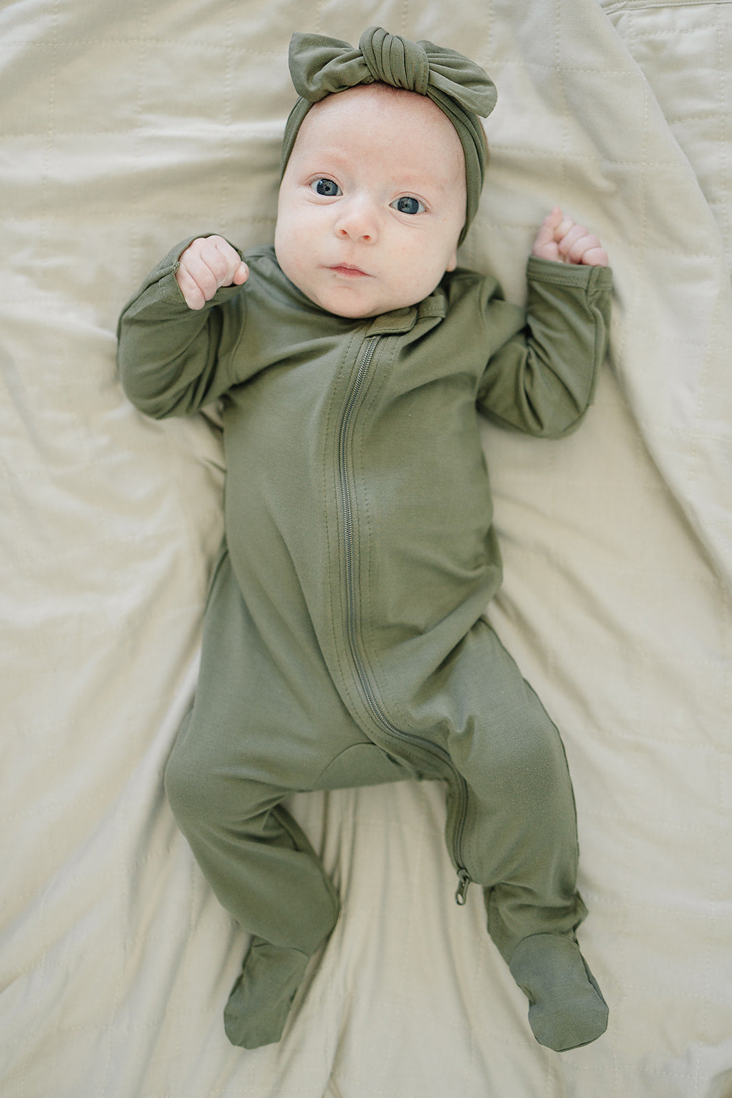 Close-up of an olive green knotted bamboo head wrap bow on a baby.