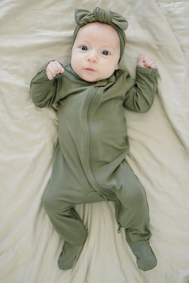 Close-up of an olive green knotted bamboo head wrap bow on a baby.