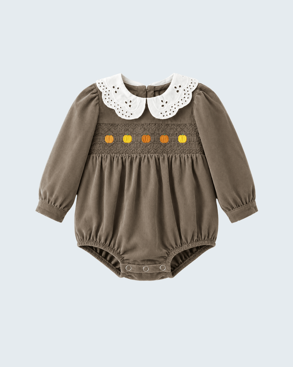 A baby long-sleeve smocked romper in taupe brown, featuring a white eyelet Peter Pan collar and a smocked chest band with orange and yellow embroidered details, shown on a light gray background.