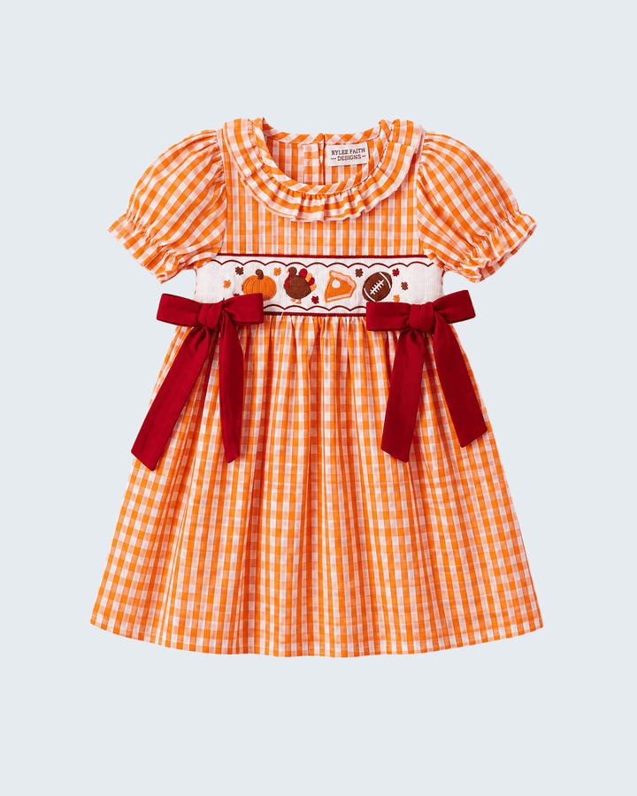 Orange gingham embroidered dress front with ruffled collar, puff sleeves, red ribbon bows