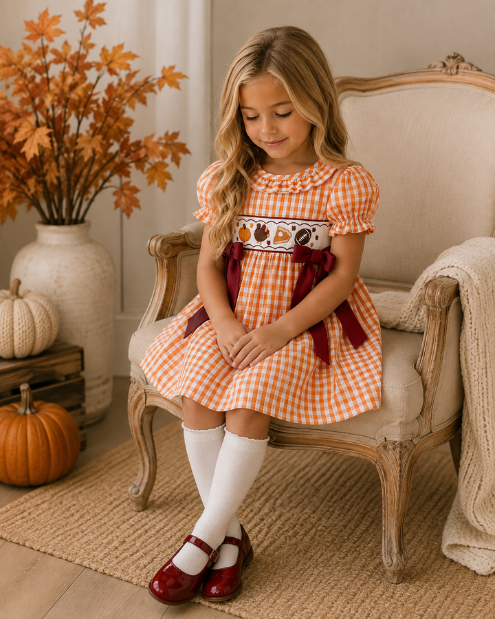 Orange gingham embroidered dress with puff sleeves, ruffled collar and red side bows