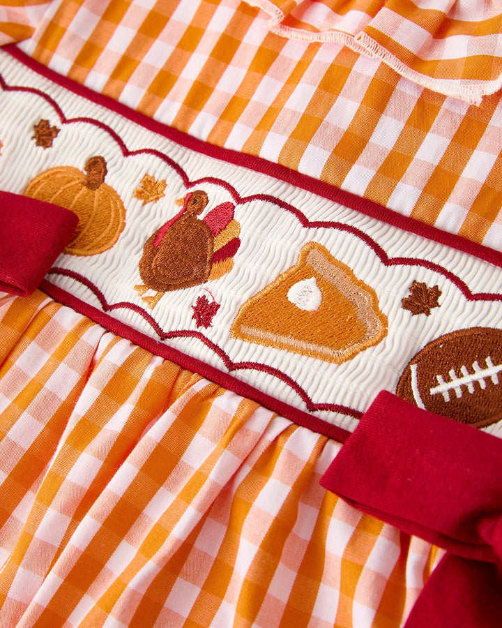 Embroidered fall motif panel on orange checkered girls dress with turkey and leaves