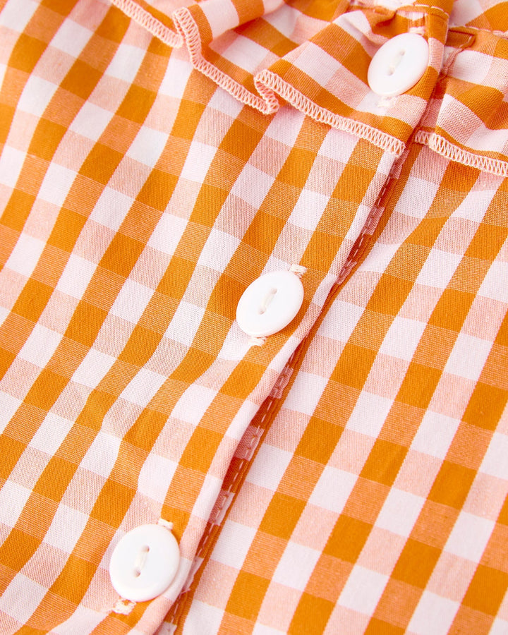 Orange checkered girls dress placket with white buttons and embroidered trim