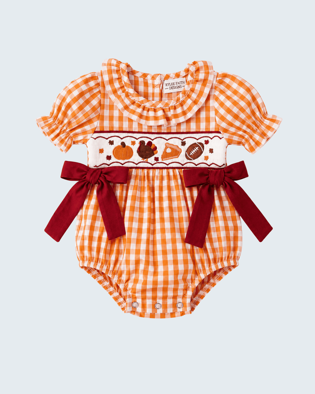 Orange gingham embroidered romper with heart-style panel and red bow waist ties