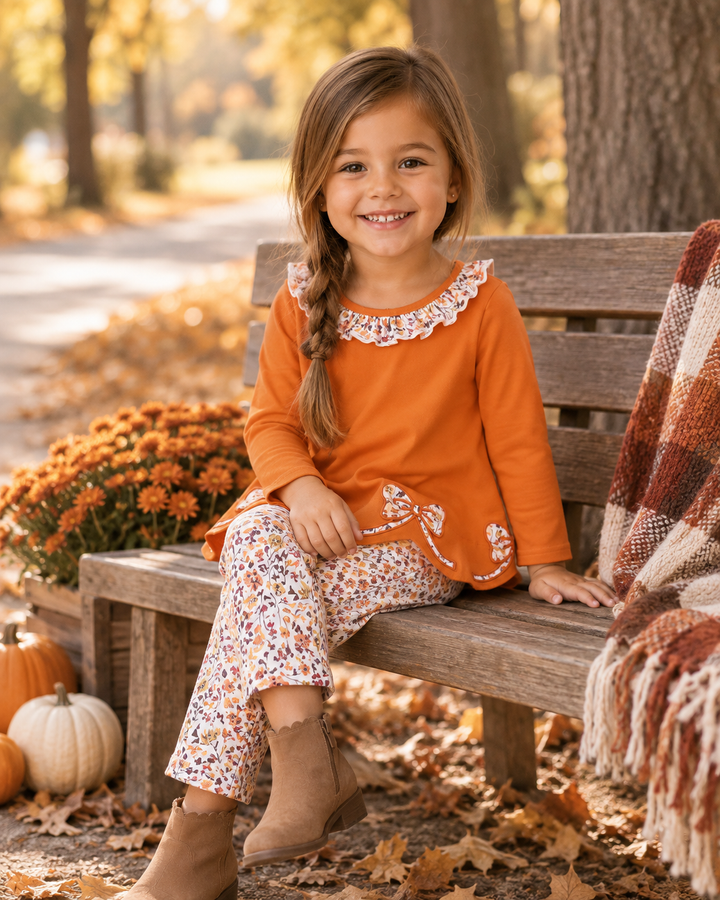 Orange ruffle-collar top and floral print pants worn by a child