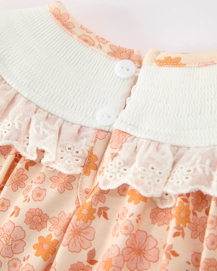 Orange floral baby romper with white elastic waist and button placket