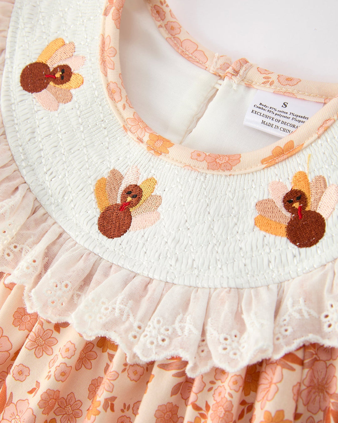 Orange floral lace dress close-up: white yoke with embroidered flower details