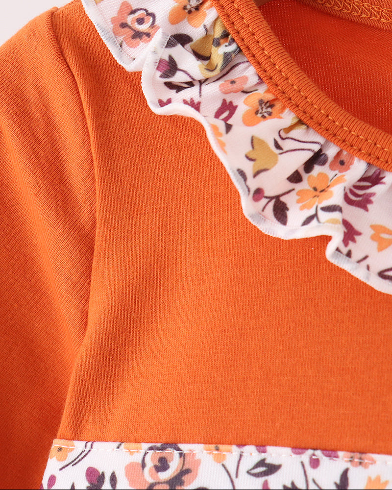 Orange long-sleeve top with floral ruffled neckline and button placket