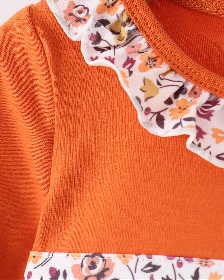 Orange long-sleeve top with floral ruffled neckline and button placket