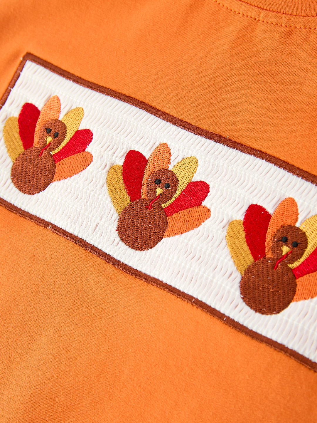 Orange T-shirt with embroidered turkey graphic patch on chest