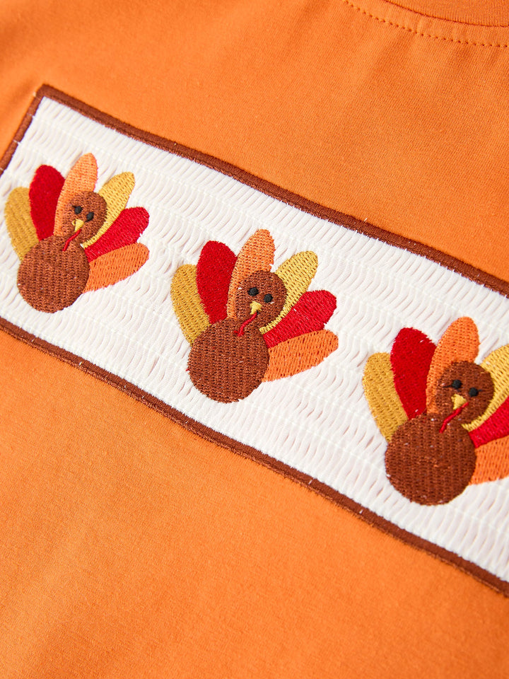 Orange T-shirt with embroidered turkey graphic patch on chest