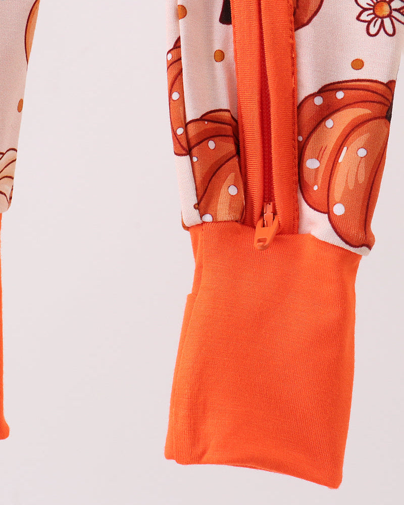 Pumpkin print romper front leg with orange cuff and zipper opening