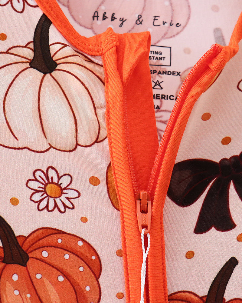Zip-front bamboo romper with orange trim and pumpkin floral print