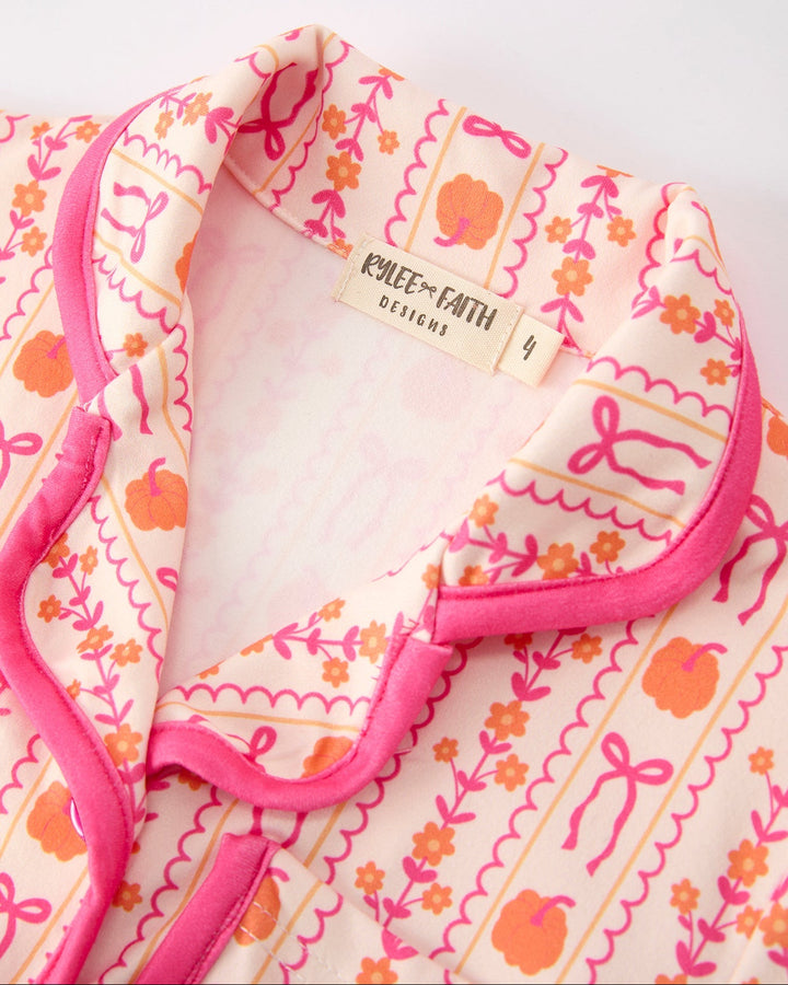 Girls pajama top neckline with pink trim and small tag label on peach patterned fabric