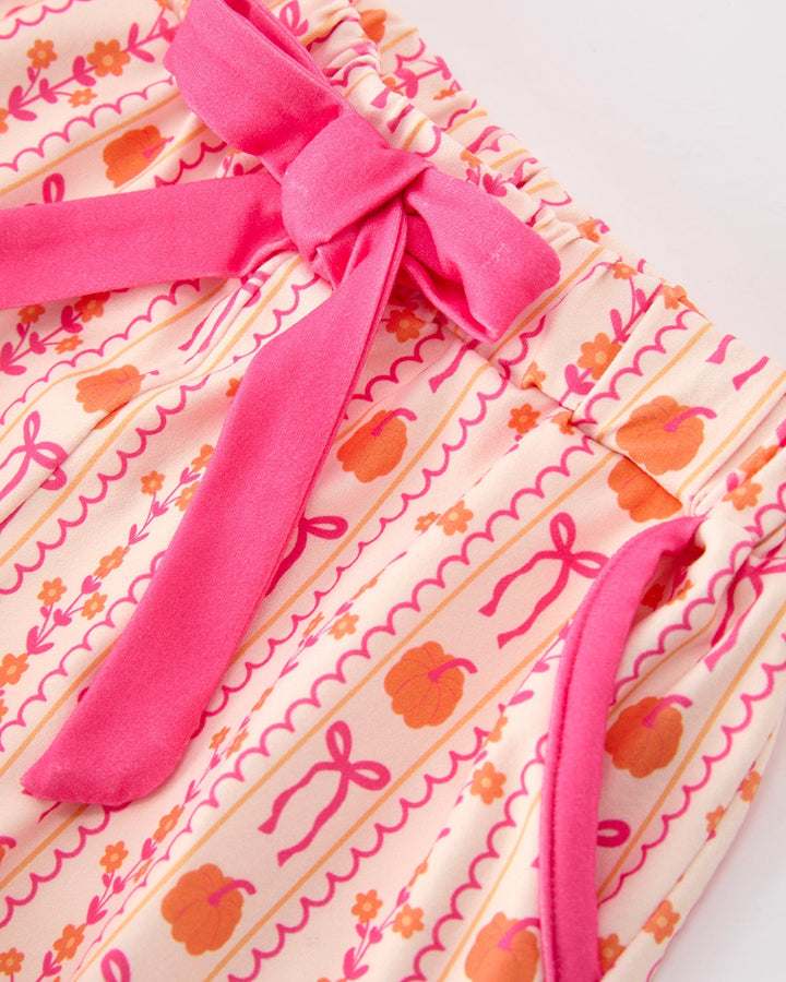 Girls pajama top and shorts with long pink sash bow and ruffled trim on patterned fabric