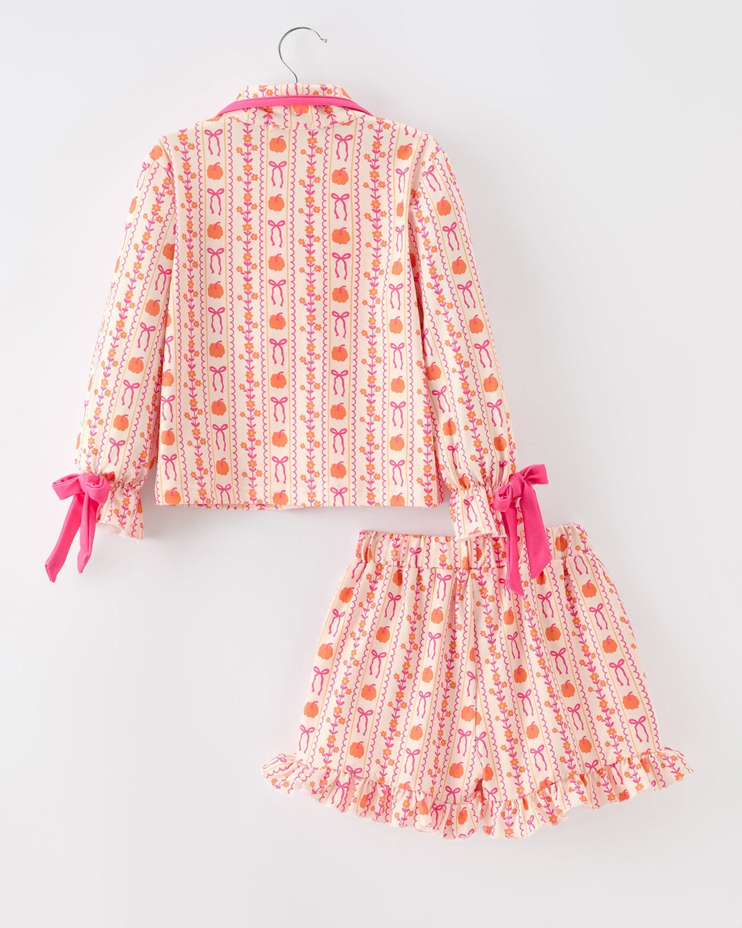 Girls pajama set, back view with ruffled long sleeves and short skirt; pink tie bows