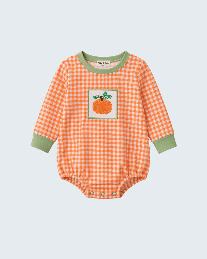 A baby long-sleeve bodysuit in orange and white gingham with sage green trim on the collar and cuffs, featuring a pumpkin patch graphic on the chest.