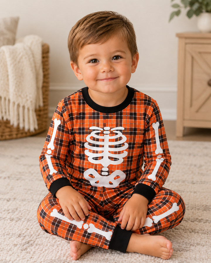 Orange plaid Halloween pajama pants with white skeleton graphic and black cuffs