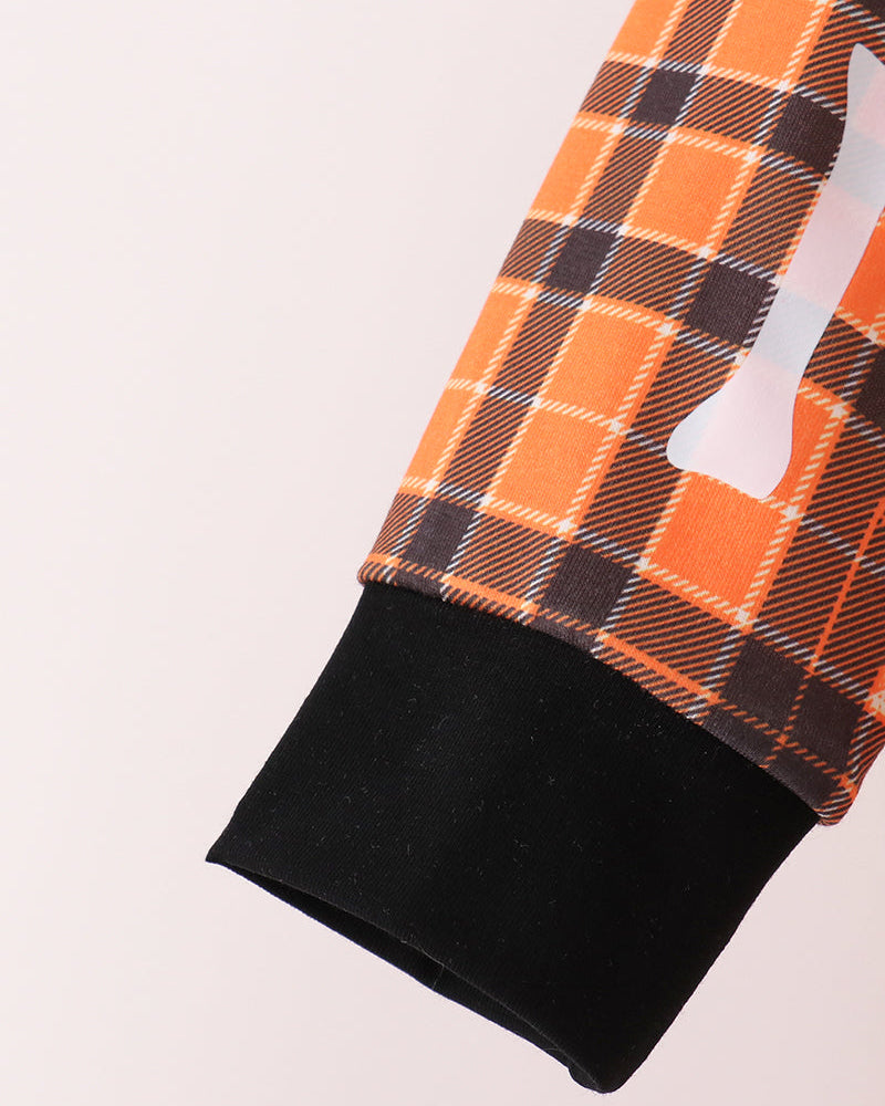 Orange plaid pants leg with black cuff and white bone applique