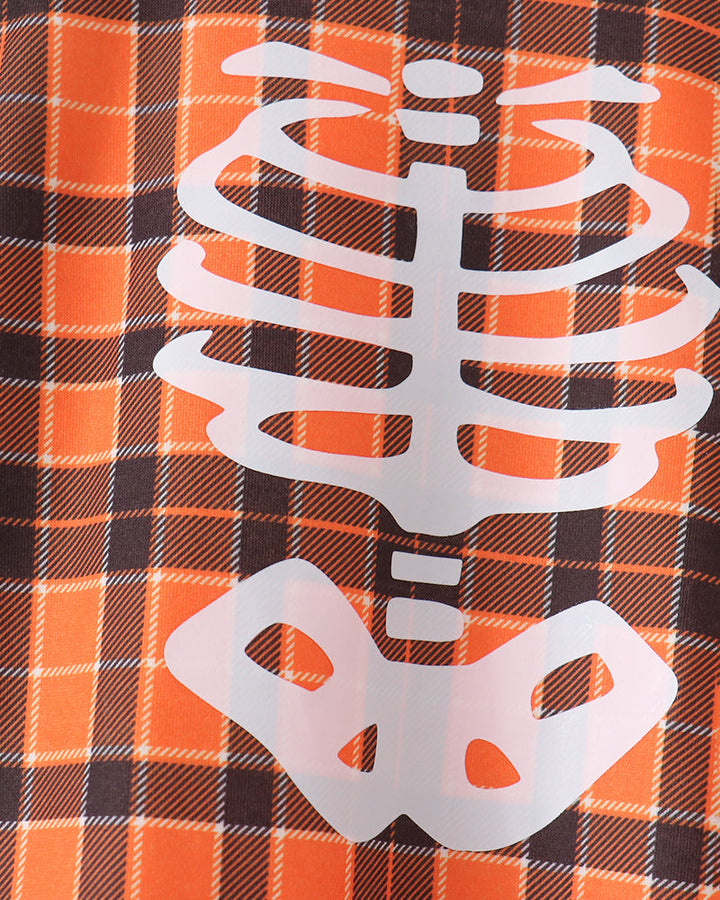 Orange and black plaid romper with large white skeleton graphic