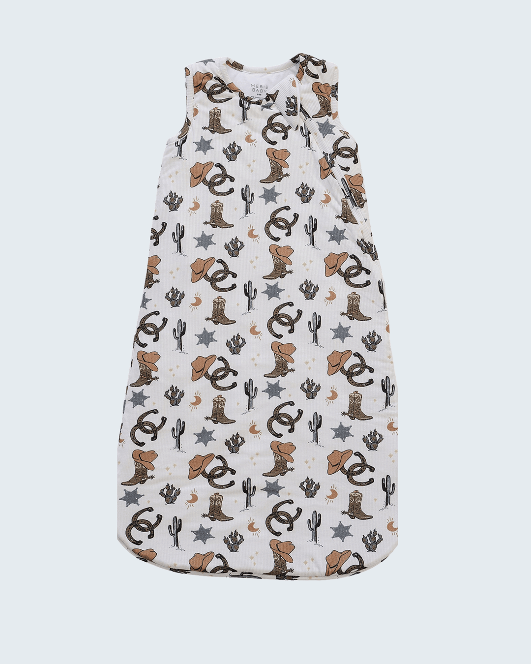 A sleeveless baby sleeping bag or swaddle with a western-themed print featuring cowboy boots, cacti, stars, and moons on an off-white background.