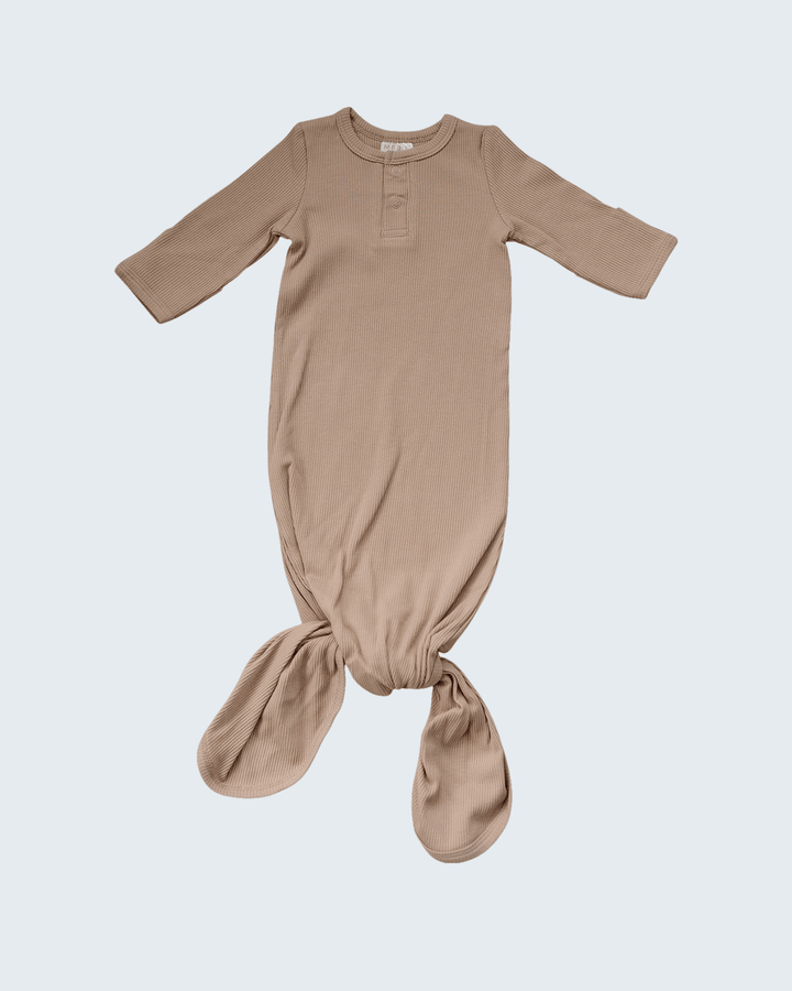 Pale pink baby onesie with long sleeves on a light gray background