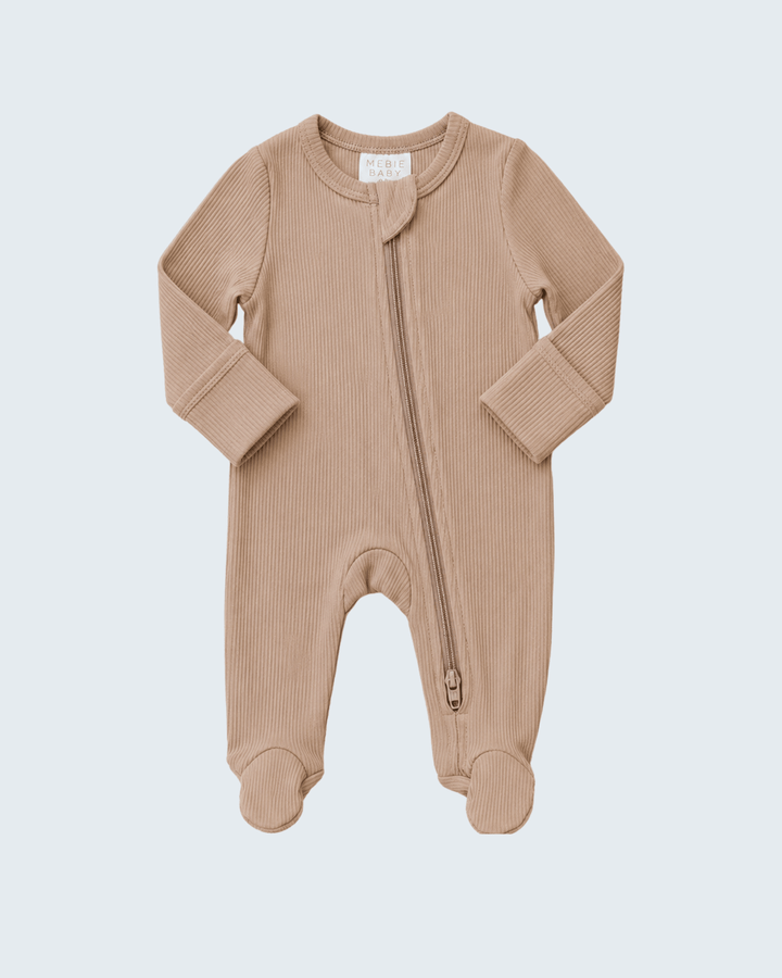 A baby long-sleeve footed sleeper in a warm beige ribbed knit fabric, featuring a front zipper and integrated footies, shown on a light gray background.