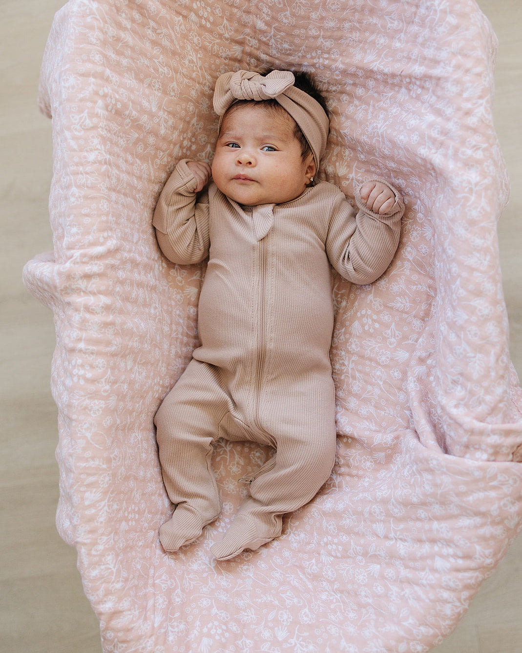 Organic cotton ribbed zipper footie on baby, pale pink with front zipper