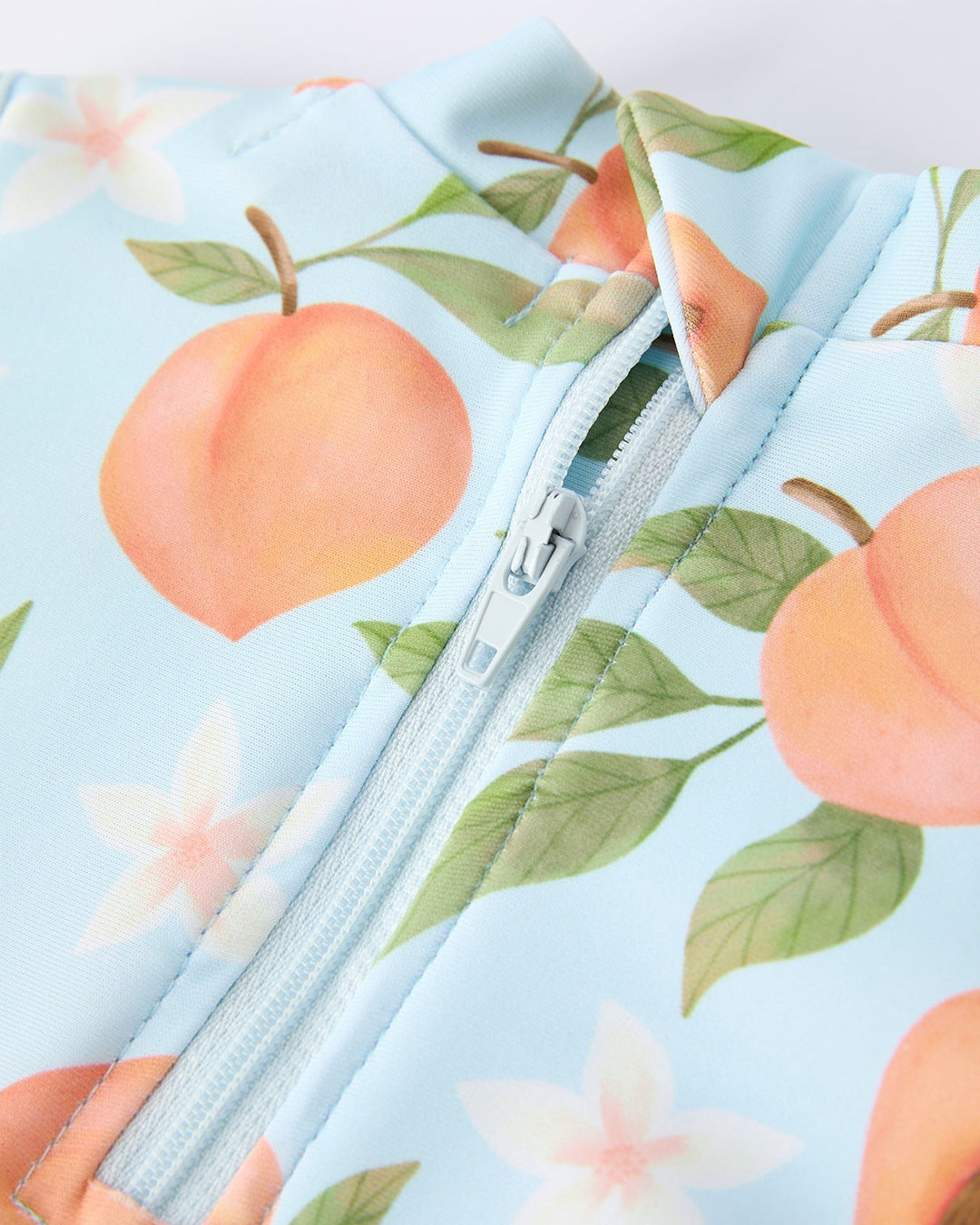 Swimsuit with peach and floral pattern on a light blue background