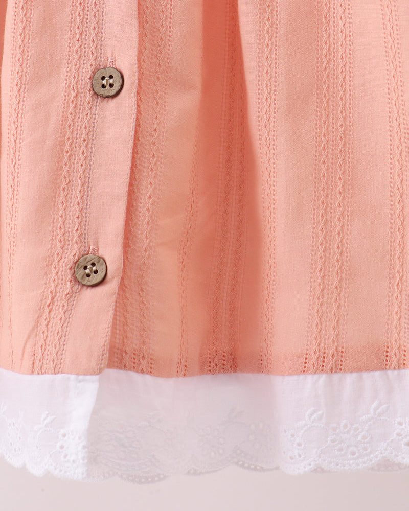Peach dress bodice with vertical stitching texture, two button placket, and lace hem